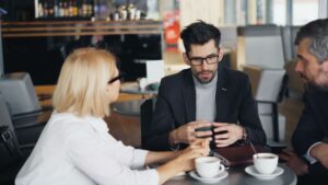Drei Menschen besprechen in einem Café gemeinsam finanzielle Themen